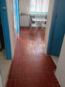 a room with a table and chairs and a red tile floor at Pousada Nossa Senhora Da Polônia in Cachoeira Paulista