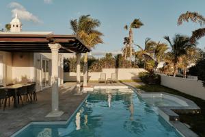 a swimming pool in the backyard of a house at Hotel Villas Alondra in Puerto del Carmen