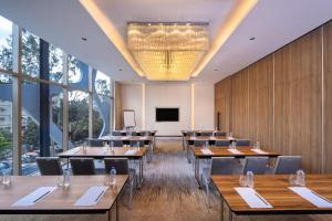 a conference room with tables and chairs and a screen at Hyatt Place Dhaka Uttara in Dhaka