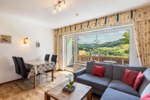 a living room with a couch and a table and a window at Ferienbauernhof Gördes in Schmallenberg