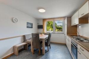 a kitchen with a table and chairs and a window at Ferienwohnung Hacke in Schmallenberg +13 photos