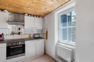 a kitchen with white cabinets and a window at Ferienwohnung Hagen in Pfalzgrafenweiler