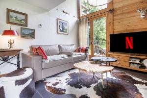 レ・ズッシュにあるChalet Taconnaz - Warm & Cosy 3BR Chalet with Fireplace in Nature - By Cozee Rentalsのソファとテレビのあるリビングルーム
