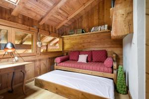レ・ズッシュにあるChalet Taconnaz - Warm & Cosy 3BR Chalet with Fireplace in Nature - By Cozee Rentalsの赤いソファ付きの木造の部屋