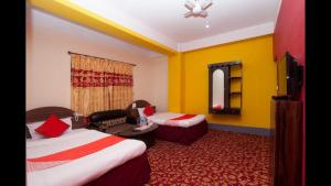 a hotel room with two beds and a couch at Hotel Green View in Ilām