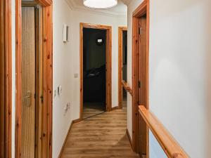 a hallway with wooden floors and a hallway with doors at Pine View in Cairisiadar