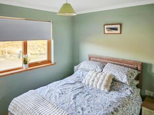 a bed in a bedroom with a window at Pine View in Cairisiadar +3 photos