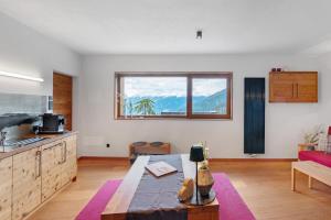 a kitchen and living room with a large window at Ansitz Röfen in Burgusio