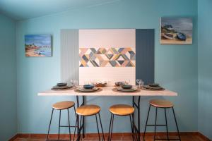 a bar with stools in a room with paintings at Le Cabanon de vacances avec patio in Six-Fours-les-Plages +14 photos