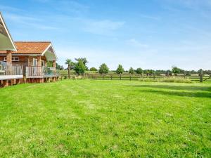 a large field of grass next to a house at Chestnut Lodge in Old Buckenham