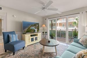 a living room with a tv and a couch and a table at Beach Club, Unit 134 in East End