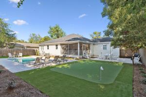 a backyard with a putting green and a house at Getaway Cottage - 615 Bartow St in Saint Simons Island