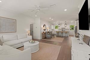 a white living room with a couch and a table at Getaway Cottage - 615 Bartow St in Saint Simons Island
