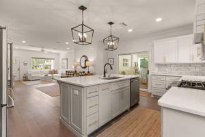 a kitchen with white cabinets and a kitchen island at Getaway Cottage - 615 Bartow St in Saint Simons Island