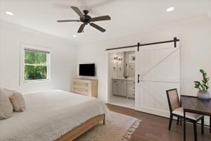 a bedroom with a bed and a sliding barn door at Getaway Cottage - 615 Bartow St in Saint Simons Island +28 photos