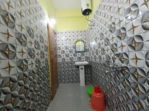 a bathroom with a sink and a wall with tiles at Rupsadeya Homestay in Mangpu +18 photos