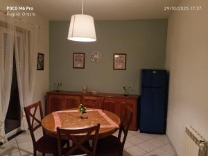 a dining room with a table and a blue refrigerator at I capricci dell' Etna suite in Mascalucia