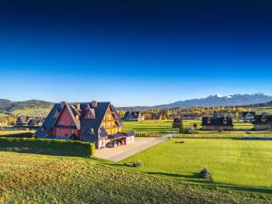 a large house in the middle of a green field at Czerwone Wierchy - sauna i jacuzzi wliczone w cenę pobytu - blisko stoku narciarskiego - zachęcamy do rezerwacji zimowych pobytów w atrakcyjnych cenach! in Białka Tatrzanska