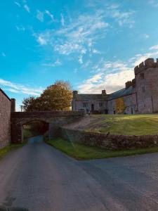 an old castle with a bridge over a road at Holly Cottage - Village location, Lake District in Penrith