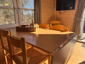 a dining room with a large wooden table and chairs at Vedersø Strand Camping in Ulfborg