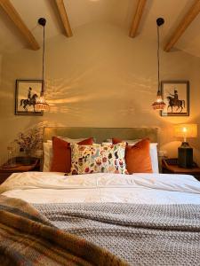 a bedroom with a bed with two lights above it at Holly Cottage - Village location, Lake District in Penrith