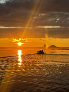 een boot op het strand bij zonsondergang met een regenboog bij Eldur Seaside Cabin in Stavang