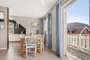 een keuken en eetkamer met een tafel en een balkon bij Eldur Seaside Cabin in Stavang