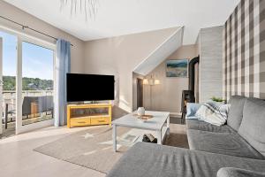 een woonkamer met een bank en een flatscreen-tv bij Eldur Seaside Cabin in Stavang