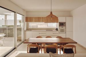 プエルト・デル・カルメンにあるVillas Alondraの木製のテーブルと椅子のあるキッチンとダイニングルーム