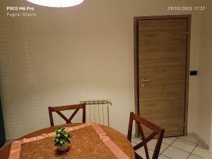 mesa de comedor con 2 sillas y puerta en I capricci dell' Etna suite, en Mascalucia 2 fotos más