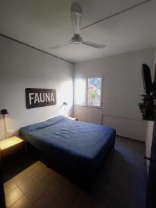 a bedroom with a blue bed and a sign on the wall at HOSTEL La Casa de Li - En in Chilecito