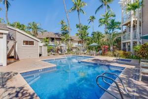 ワイレアにあるGrand Champions 179 · GC 179 Last Minute Deal at 3BD Wailea Condのヤシの木が茂る家の前のスイミングプール