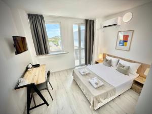 a bedroom with a bed and a desk and a window at Студия за нощувки - Стара Загора in Stara Zagora