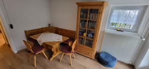a room with a table and chairs and a book shelf at Ferienhaus Barbey in St. Blasien