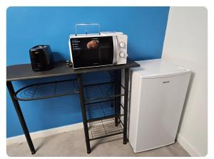 a microwave sitting on a table next to a refrigerator at Alphonse in Felletin