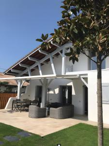 a white house with a patio with a tree at Chambre D'hote Chez Amaya in Gujan-Mestras