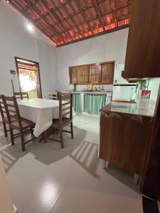 cocina con mesa, sillas y barra en Flor de Lótus - Ilha de Boipeba, en Isla de Boipeba