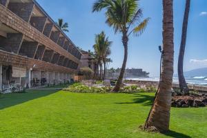 a resort with palm trees and the ocean at Kulakane 306 · KK 306 Remodeled BeachFront 2BD w Ocean Views AC in Kahana