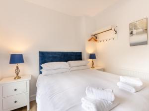 a bedroom with a white bed and two night stands at Levans Cottage in Lindale