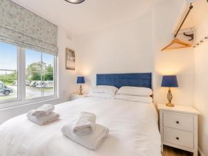 a bedroom with a large white bed with towels on it at Levans Cottage in Lindale +10 photos