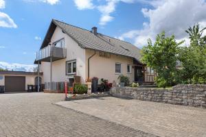 a white house with a stone wall at Haus Claudia in Fulda