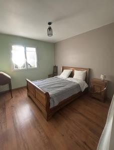 サルにあるMaison proche du bassin d’Arcachonのウッドフロアのベッドルーム1室(窓付)