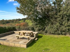 a wooden picnic table sitting on top of a field at Revita in Hale