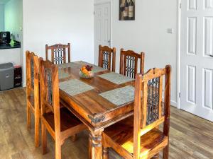 a wooden dining room table with chairs and a bowl of fruit on it at Revita in Hale
