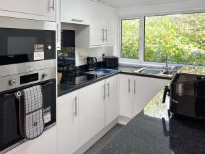 a kitchen with white cabinets and black appliances at Revita in Hale +9 photos