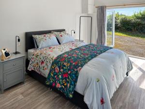 a bedroom with a bed with a floral bedspread and a window at Revita in Egremont