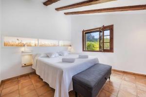 a white bedroom with a bed and a window at Can Verd Vall De Colonya in Pollença +28 photos