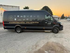 فندق Sadot Hotel Ben Gurion Airport - an Atlas البوتيكي في عساف هاروفة: سيارة فان سوداء متوقفة في موقف للسيارات