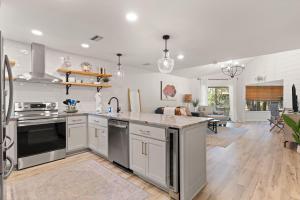 Harbour Oaks, Unit 618 في Demere Park: مطبخ مع أجهزة ستانلس ستيل وغرفة معيشة