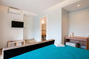 a bedroom with a blue bed and a television at Vico degli Orti in Mistretta